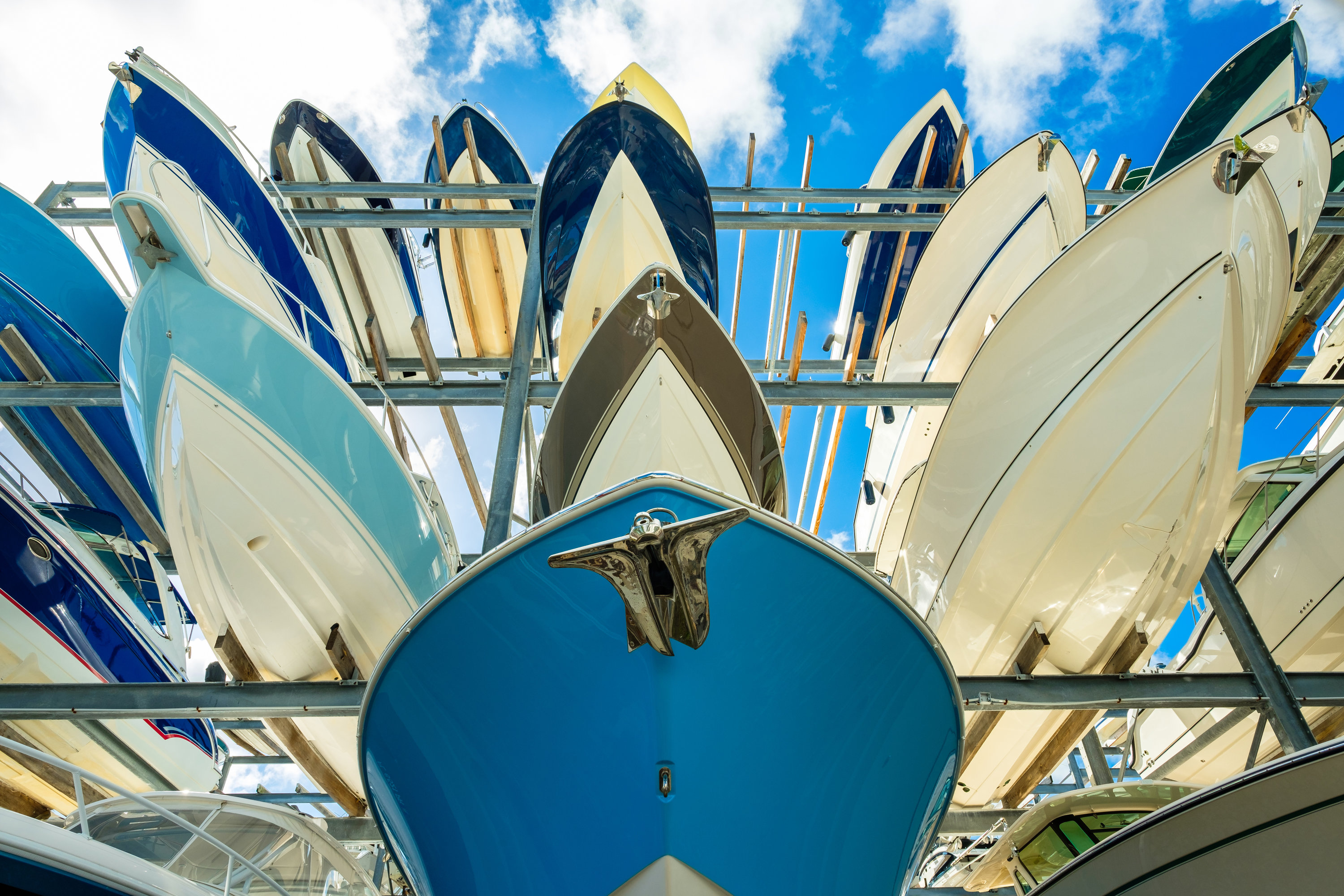 Boats stacked in a outdoor storage facility.